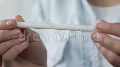 女人手指握着孕检，转动它显示一条线，不孕不育